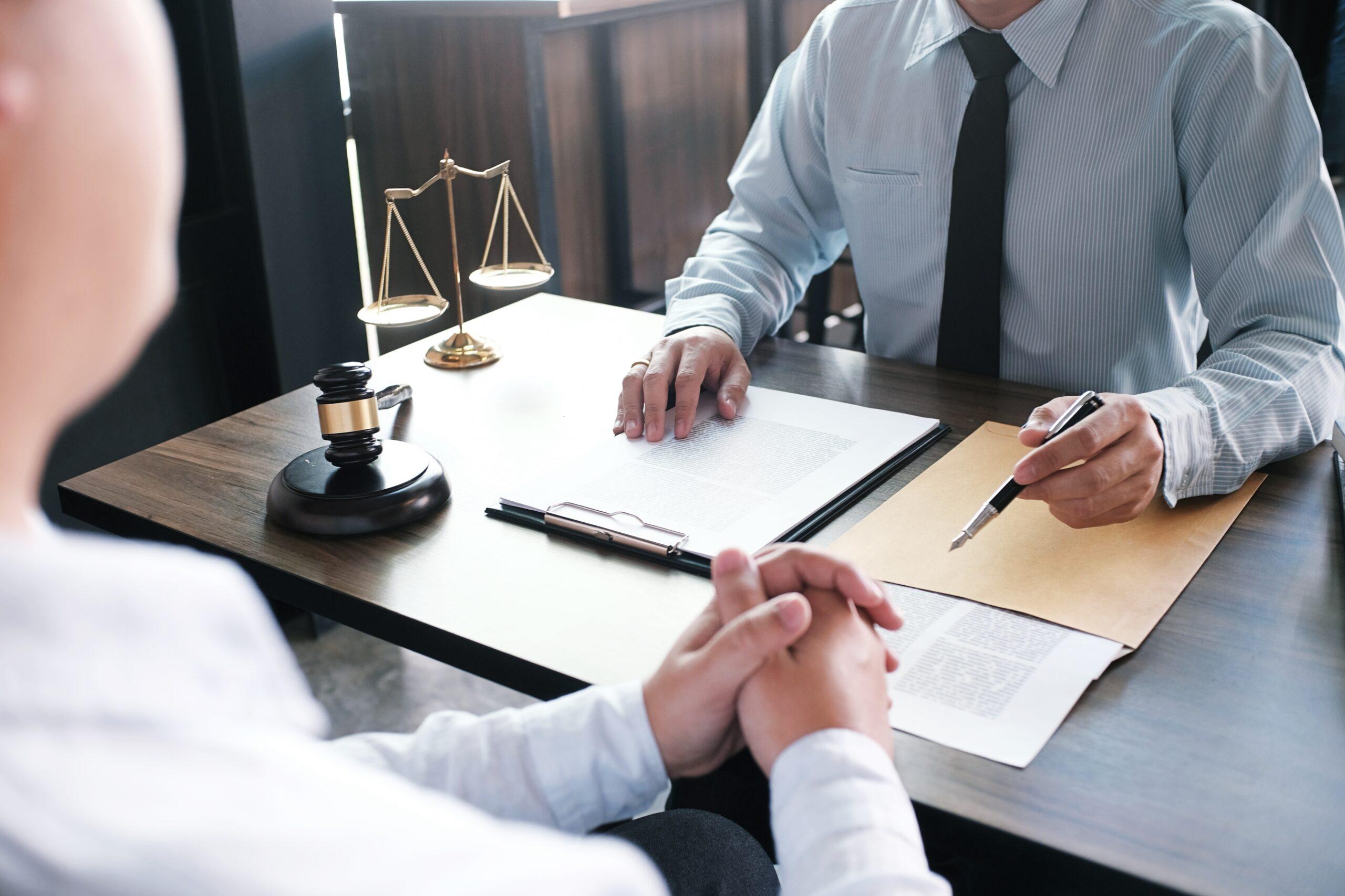 legal defense team with client over desk